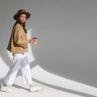 beautiful fashionable woman posing in studio on white background in studio. fashionable female walking with coffee to go. fashion concept - fashion stock pictures, royalty-free photos & images