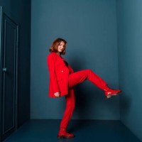 beautiful fashionable woman walking in a room with a door in a red suit indoors. concept - fashion stock-fotos und bilder