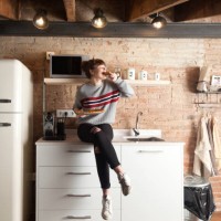beautiful girl eating pizza in a modern kitchen - home decoration stock pictures, royalty-free photos & images