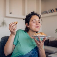 beautiful girl enjoying the taste of a fresh croissant - junk food stock pictures, royalty-free photos & images
