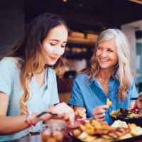 beautiful senior mother and daughter eating lunch together at restaurant - food stock pictures, royalty-free photos & images
