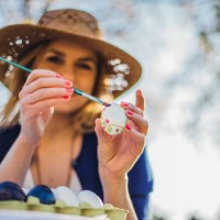beautiful woman decorating easter eggs in garden for holiday - garden decoration stock pictures, royalty-free photos & images