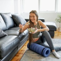 beautiful woman eating fresh salad after intensive home workout - food stock pictures, royalty-free photos & images