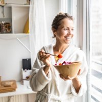 beautiful woman eating healthy vegetable salad wearing bathrobe - food stock pictures, royalty-free photos & images