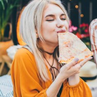 beautiful woman eating pizza. - junk food stock pictures, royalty-free photos & images