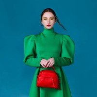 beautiful woman in green dress holding a red handbag - fashion stock pictures, royalty-free photos & images