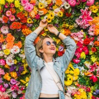 beautiful woman smiling in front of flower wall - garden decoration stock pictures, royalty-free photos & images