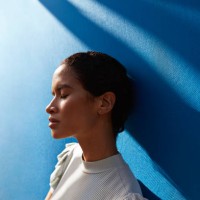 beautiful woman standing against blue wall - fashion stock pictures, royalty-free photos & images