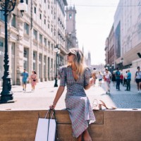 beautiful woman with sunglasses looking away while sitting on the city wall - fashion stock pictures, royalty-free photos & images