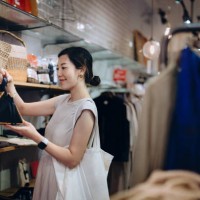 beautiful young asian woman shopping for personal accessories, looking at a handbag in boutique. sale season. seasonal shopping - fashion stock pictures, royalty-free photos & images