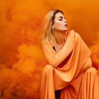 beautiful young blond female woman dancing and posing in orange smoke in outdoor countryside setting - fashion stock pictures, royalty-free photos & images