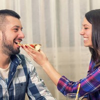 beautiful young couple eating pizza together - junk food stock pictures, royalty-free photos & images