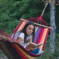beautiful young girl lying and reading a book - garden decoration stock pictures, royalty-free photos & images