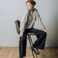 beautiful young redhead girl in a warm sweater and casual clothes sitting on a chair indoors - fashion stock pictures, royalty-free photos & images