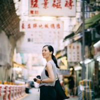 beautiful young woman carrying camera exploring and walking through local city street - travel stock pictures, royalty-free photos & images