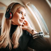 beautiful young woman listening to music through the headphones in a private jet - travel stock pictures, royalty-free photos & images