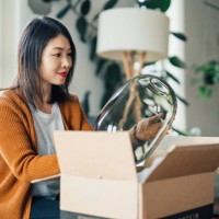 beautiful young woman unpacking parcel purchased online - home decoration stock pictures, royalty-free photos & images