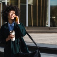 beauty woman drinking coffee while talking to the mobile in the street - junk food stock pictures, royalty-free photos & images