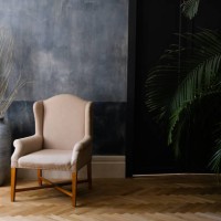 beige chair and a large vase near the window in the hall, next to a palm tree near the door. - home decoration stock pictures, royalty-free photos & images