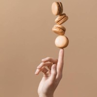 beige monochromen hintergrund mit ausgewogenen makronen - food stock-fotos und bilder