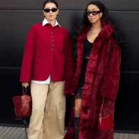 Benthe Liem wears beige wide pants, a white shirt, a red cardigan, and a tulip flower-shaped bag and Amaka Hamelijnck wears a black lace skirt, black...