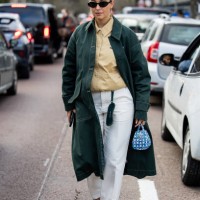 Benthe Liem wears green coat, beige button shirt, white pants, blue bag outside Lacoste during the Womenswear Fall/Winter 2024/2025 as part of Paris...