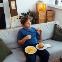 übergewichtiger teenager isst junk-food-hamburger - junk food stock-fotos und bilder