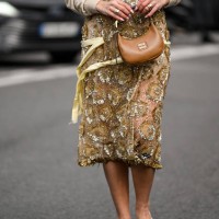 Bettina Looney is seen wearing a tan and gold sheer Miu Miu dress with brown Miu Miu bag outside the Miu Miu show during the Womenswear Fall/Winter...