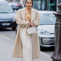 Bettina Looney wears beige fleece coat, high waisted skirt, brown blouse, Miu Miu bag, pointed heels outside Zimmermann during Paris Fashion Week -...
