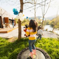 birthday girl jumping on a trampoline - garden decoration stockfoto's en -beelden