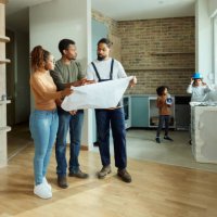 black parents and manual worker analyzing blueprints in the apartment. - home decoration stock pictures, royalty-free photos & images
