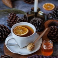 black tea with dried orange slices in a white ceramic cup on wooden presentation board - home decoration stockfoto's en -beelden