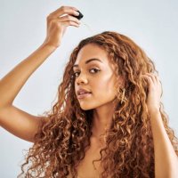 black woman, beauty and hair care with serum dropper for treatment and repair against a grey studio background. beautiful african female model in haircare with cosmetic oil pipette for healthy scalp - hairstyle stock pictures