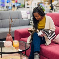 black woman chooses color and material for her new sofa bed while sitting in a department store looking at samples of materials and colors - home decoration stock pictures, royalty-free photos & images