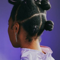 black woman standing against a purple studio background and showing her trendy and funky new hairstyle from behind. one female showing the back of her head with a creative and stylish hairdo - fashion stock pictures, royalty-