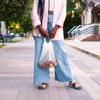 black woman with knitted tote bag against outdoors. - fashion stock pictures, royalty-free photos & images