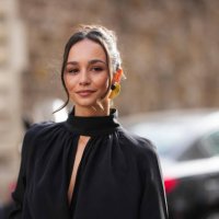 Blanca Arimany wears gold earrings, black long sleeve high neck shirt, outside Nina Ricci, during the Paris Fashion week Women's Fall/Winter...
