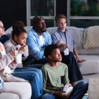 blended family of five watching tv, eating takeout - junk food stock pictures, royalty-free photos & images
