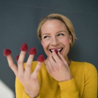 blond woman with raspberries on her fingers, laughing - food stock pictures, royalty-free photos & images