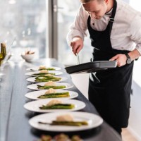 blonde caucasian male private chef plating dishes for a dinner party at a fancy apartment - food stock pictures, royalty-free photos & images