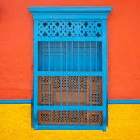 blue window in a orange and yellow background, characteristic of the town of jerico, antioquia, colombia - garden decoration stock pictures, royalty-free photos & images