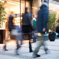 blurred people walking past illuminated fashion store - fashion stock pictures, royalty-free photos & images