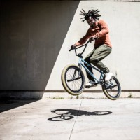 bmx rider performing jump in outdoor industrial environment - fashion stock pictures, royalty-free photos & images