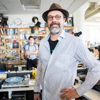 Bob Boilen, host of the Tiny Desk concert shares a laugh during sound check for artist Monika and is very timely.