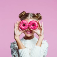 bonita chica adolescente sosteniendo donuts rosas, retrato sobre fondo rosa - food fotografías e imágenes de stock