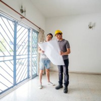 bouwvakkers die blauwdrukken in het huis met cliënten analyseren - home decoration stockfoto's en -beelden