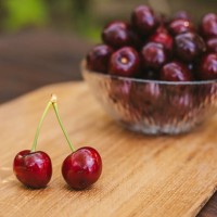 bowl of cherries on wood background - home decoration stock-fotos und bilder