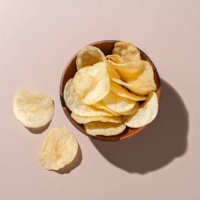 bowl of potato chips on brown background - junk food stock pictures, royalty-free photos & images