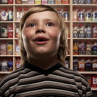 boy (6-8) in sweetshop, close-up (digital composite) - junk food stock pictures, royalty-free photos & images