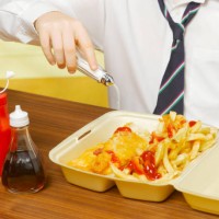boy (8-10) pouring salt on fish and chips - junk food stock pictures, royalty-free photos & images